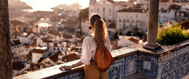 Scene with a female tourist who is walking on the street of Iberic city and poses in a famous, most recognizable places with breathtaking view